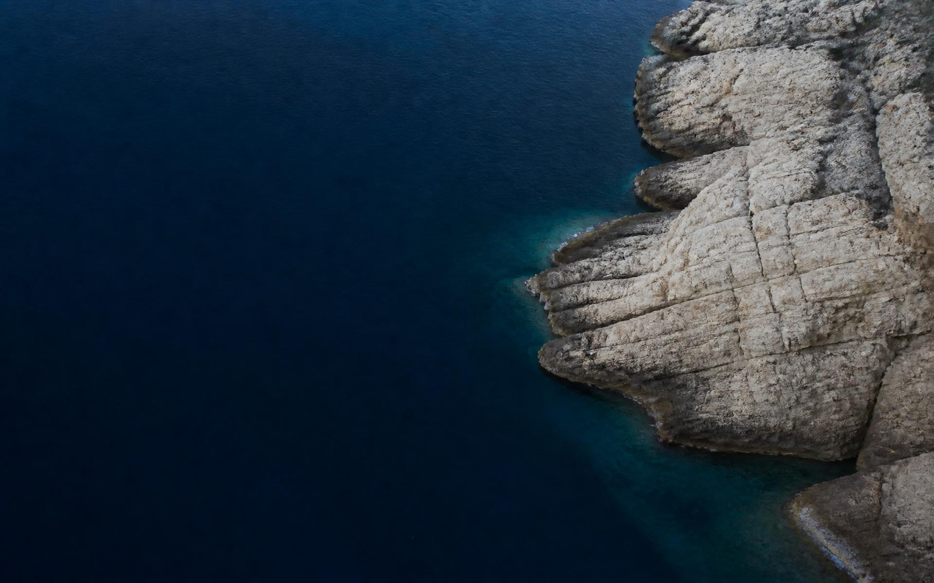 Aerial view of deep Mediterranean water meeting a limestone coastline